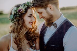 Mariés souriants au coucher du soleil, la mariée porte une couronne de fleurs