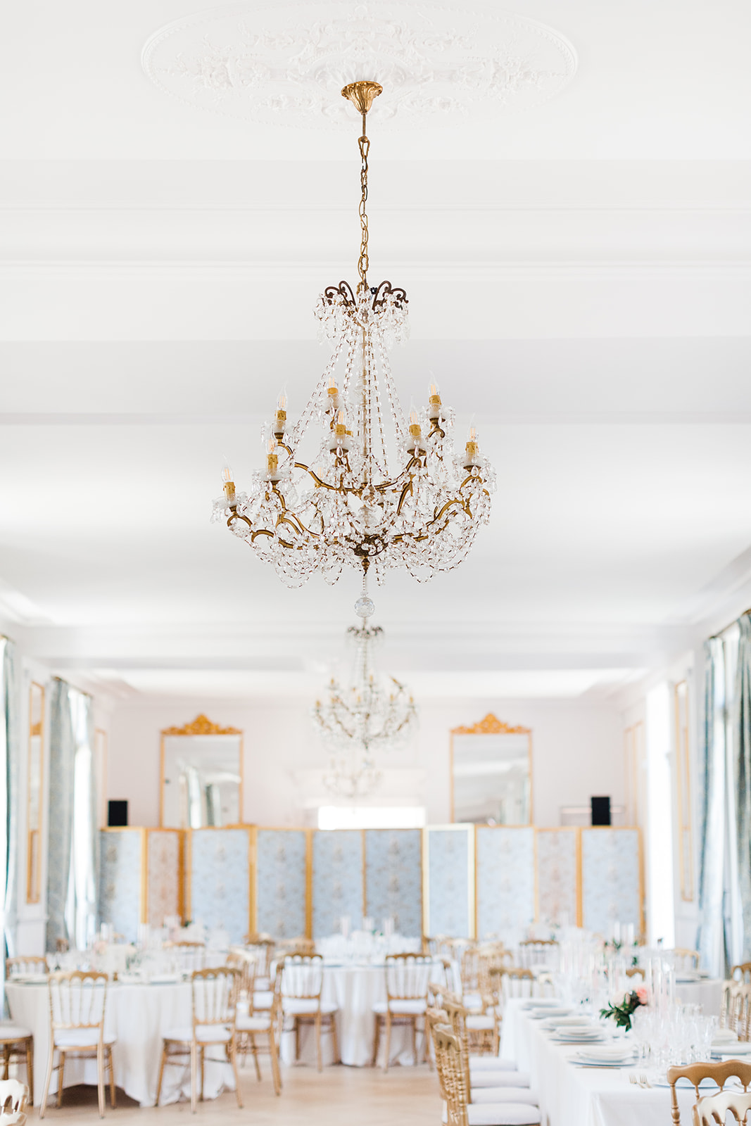 Salle de réception de mariage avec lustres dorés et tables élégamment dressées