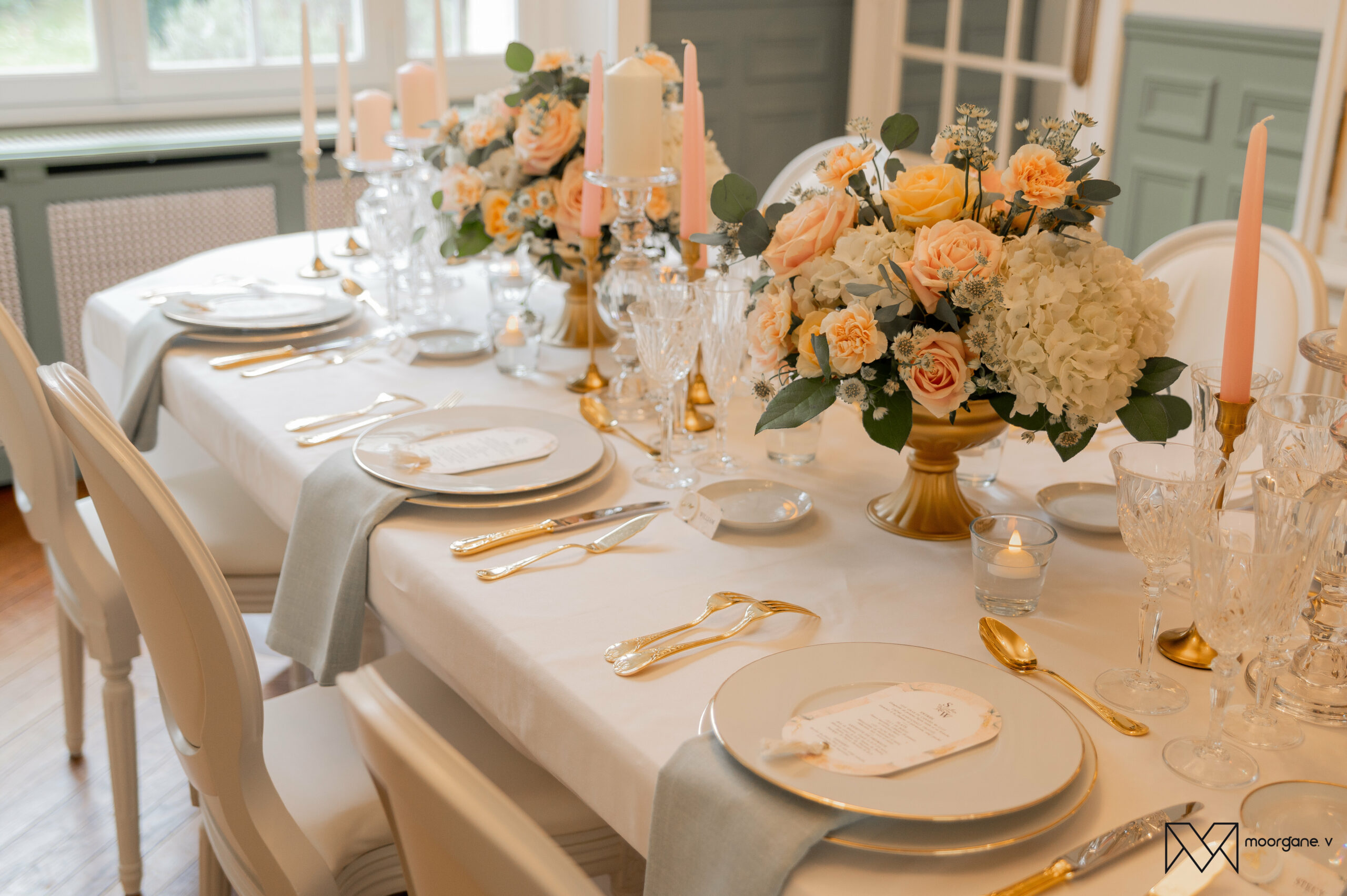 Table de mariage élégante avec vaisselle dorée et centre de table fleuri