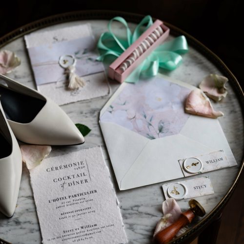 Papeterie de mariage, chaussures, ruban et enveloppes sur une table ronde