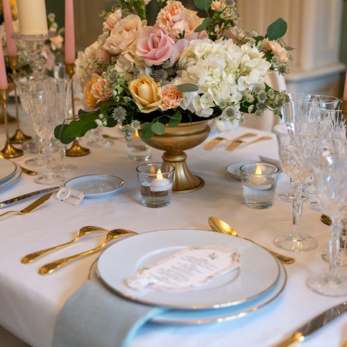 Assiette de mariage avec menu, serviette bleue et centre de table fleuri
