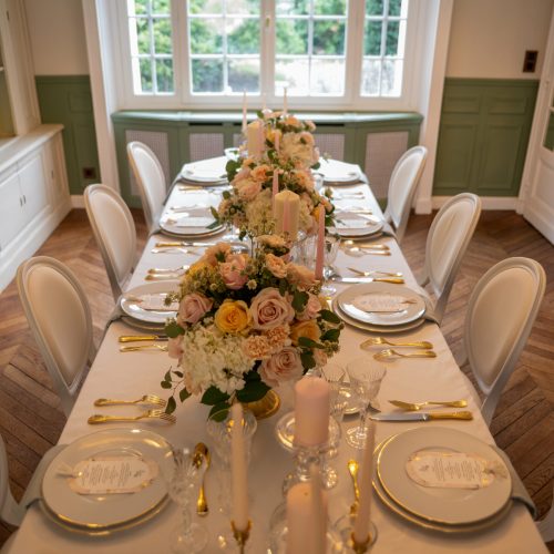 Table de mariage décorée de bougies et fleurs pastel sous lumière naturelle