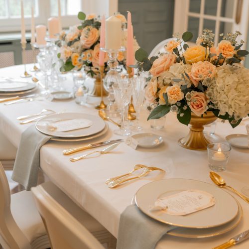 Table de mariage élégante avec vaisselle dorée et centre de table fleuri