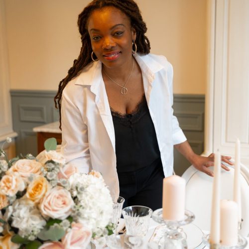 Roselaine, wedding planner, souriante devant une table de mariage décorée
