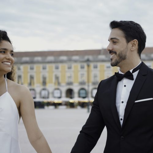 Young couple walking around the city on their wedding day. Action. Bride and groom holding hands during walking in city